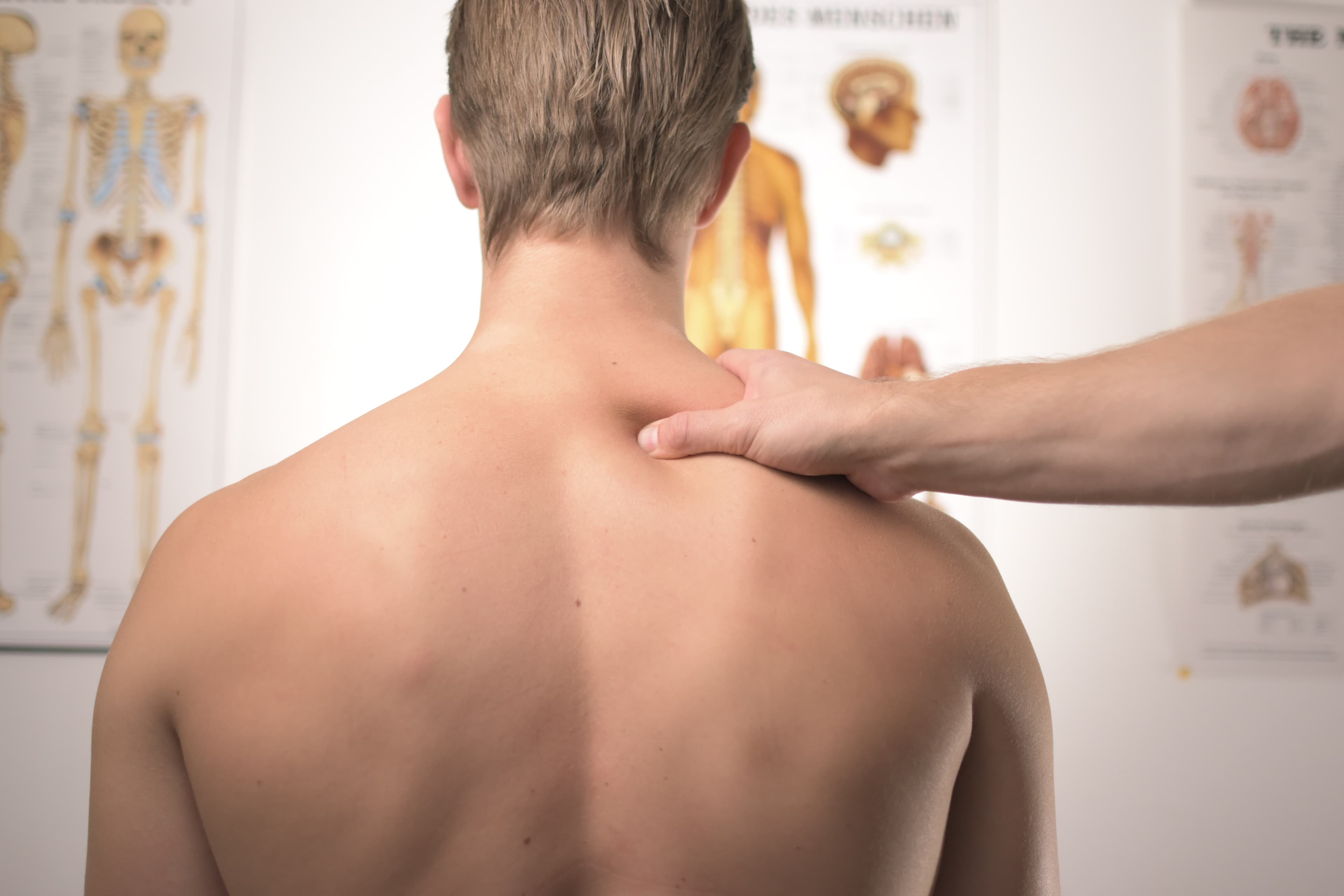 Physician massaging trap muscles